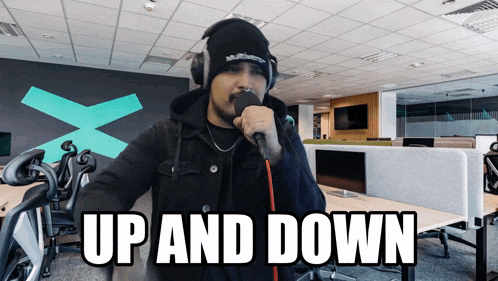 a man singing into a microphone with the words up and down written below him