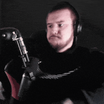 a man wearing headphones and a nike shirt is holding a microphone