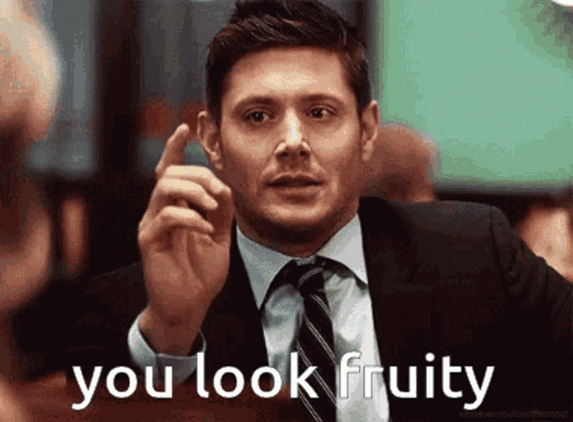 a man in a suit and tie says " you look fruity " with his finger