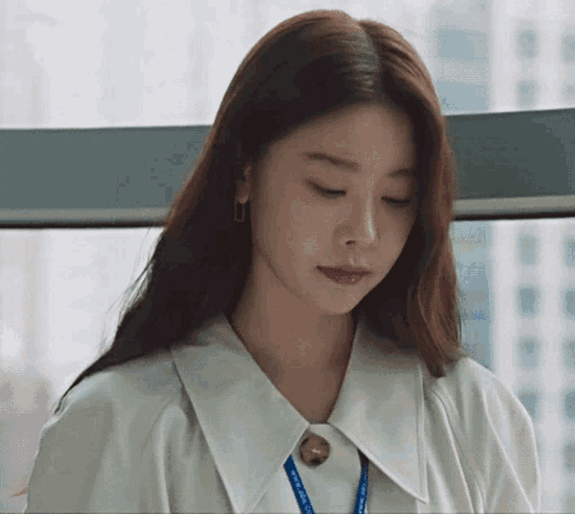 a close up of a woman wearing a white shirt and a lanyard .