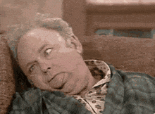 a man is laying on a couch and sticking his tongue out .