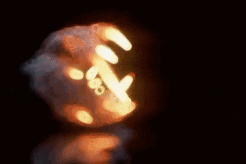 a close up of an explosion with smoke and fire coming out of it in the dark .