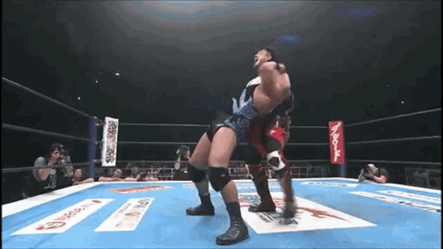 two wrestlers are wrestling in a ring with a banner that says ' aoi ' on it