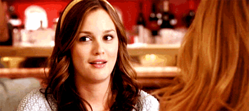 a woman wearing a headband is sitting at a table with another woman .