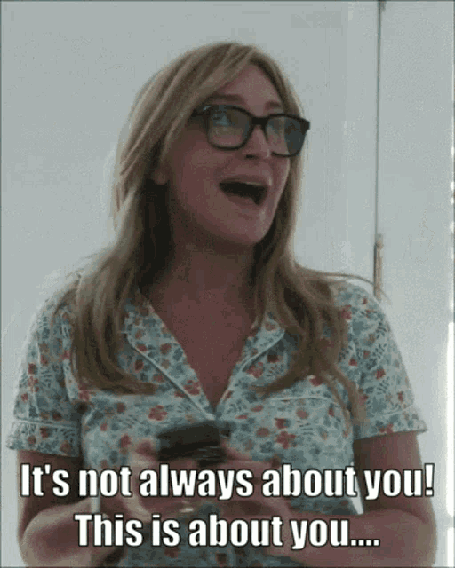 a woman with glasses is holding a cell phone and says it 's not always about you