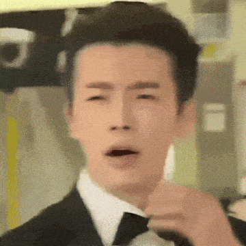 a man in a suit and tie is making a funny face
