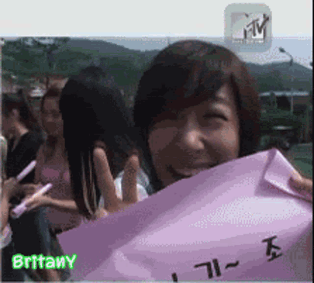 a girl holding a sign that says britany