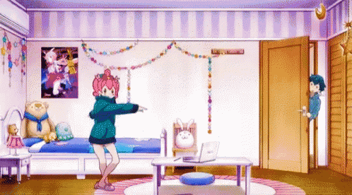 a girl is dancing in a room with a bed , table , and laptop .
