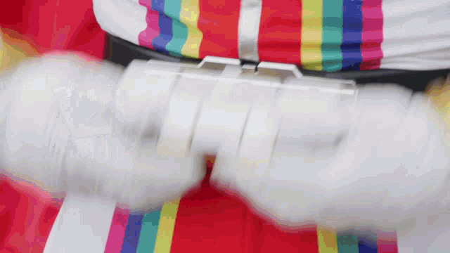a person wearing a colorful shirt is holding a white object in their hands