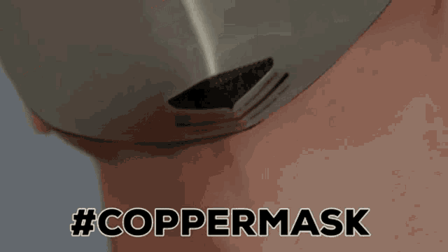 a close up of a man wearing a copper mask
