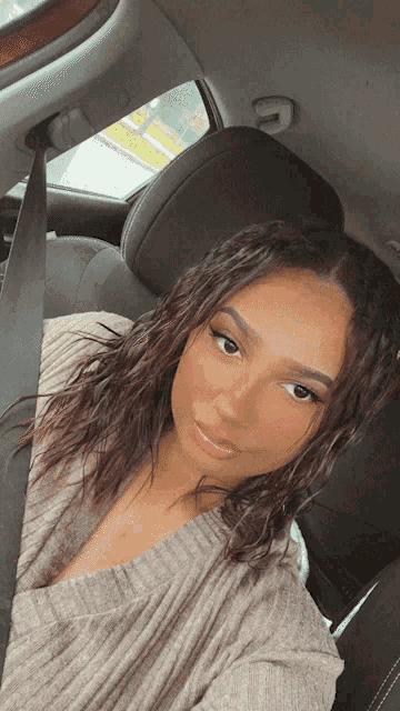 a woman sitting in a car with a seat belt on