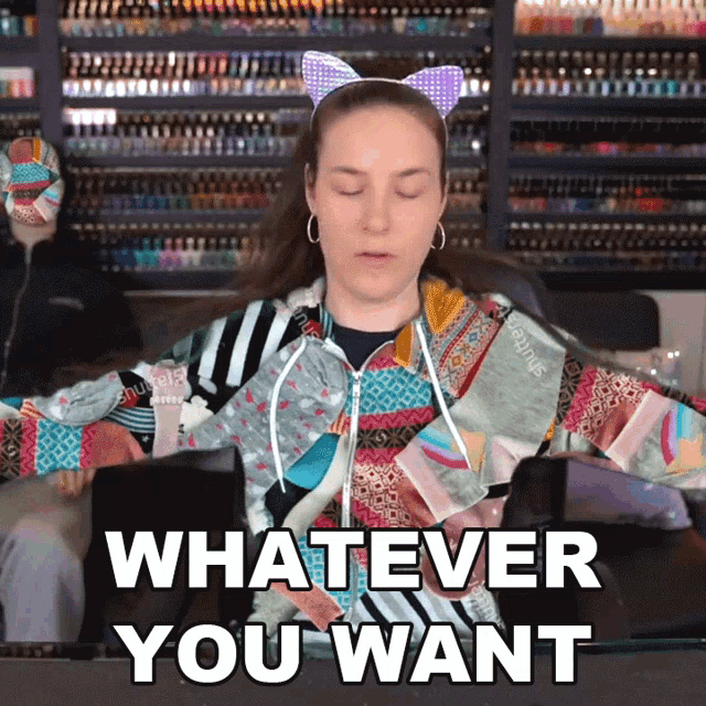 a woman wearing a cat ear headband is saying " whatever you want "