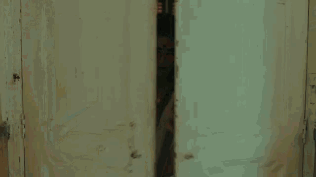 a woman in a white saree and red sunglasses is standing in a dark room