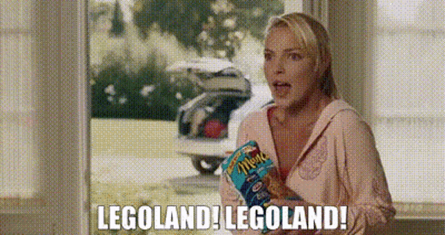 a woman is holding a bag of chips and saying legoland ! legoland !