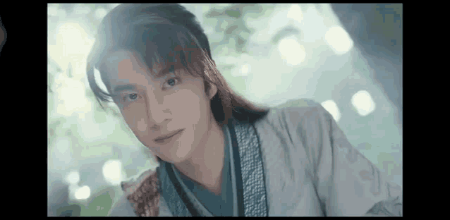 a young man with long hair is wearing a traditional costume .