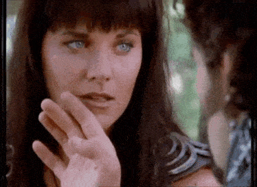 a woman with blue eyes is holding her hand to her face .