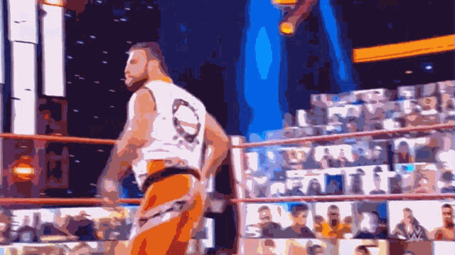 a man in a white shirt with the number 10 on it is standing in a wrestling ring