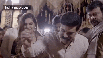 a man and a woman are dancing together in a room with other people .