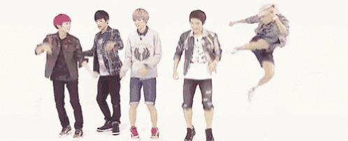 a group of young men are standing next to each other dancing .