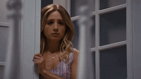 a woman in a striped top looks out of a window