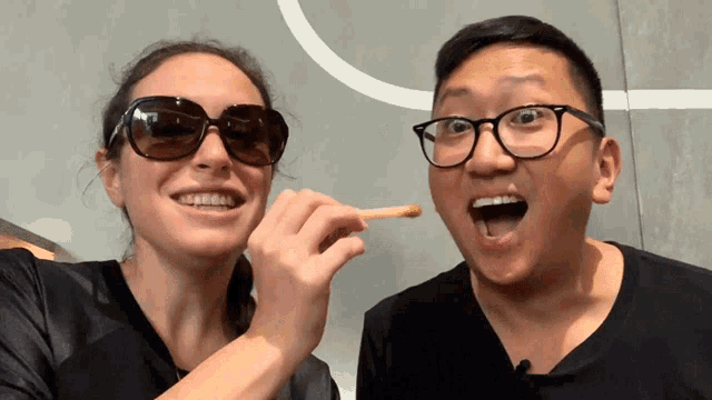 a man and a woman are eating french fries together