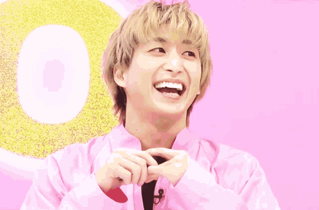 a man with blonde hair is wearing a pink shirt and a black tie