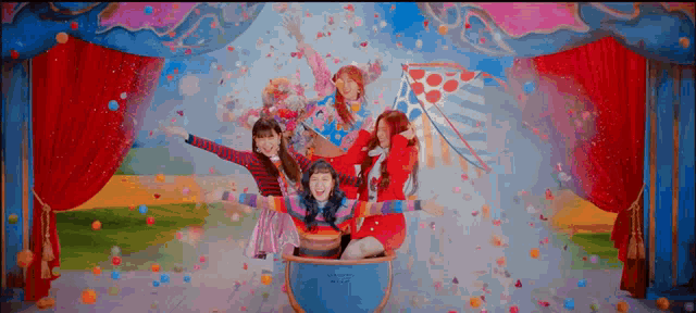 a group of girls are sitting on top of a hot air balloon surrounded by confetti .