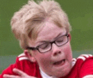 a young boy wearing glasses and a red shirt is making a face .