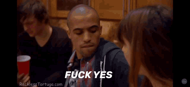 a man says fuck yes while talking to a woman in a kitchen