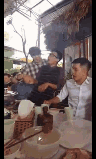 a group of men are sitting at a table in a restaurant eating food .