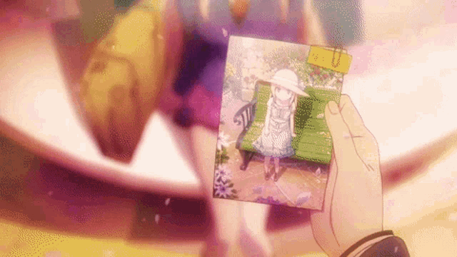 a person holding a picture of a girl sitting on a bench