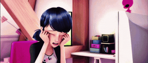 a girl is sitting at a desk with her eyes closed .
