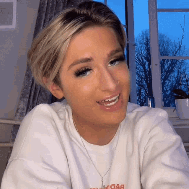 a woman wearing a white sweatshirt that says " i love you "