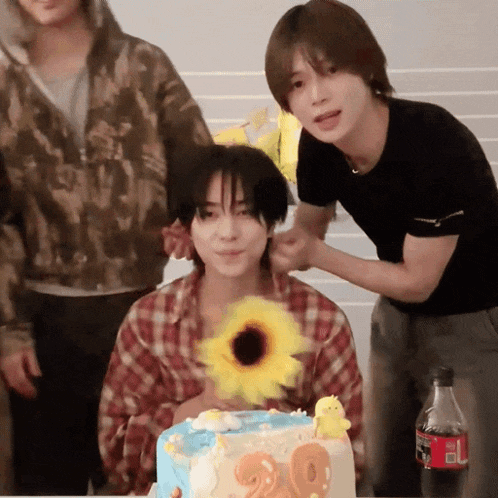 a boy is holding a sunflower in front of a cake that says 20 on it