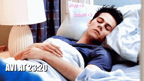 a man is sleeping in a bed with the time of 23:20