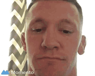 a close up of a man 's face with a momento logo in the corner