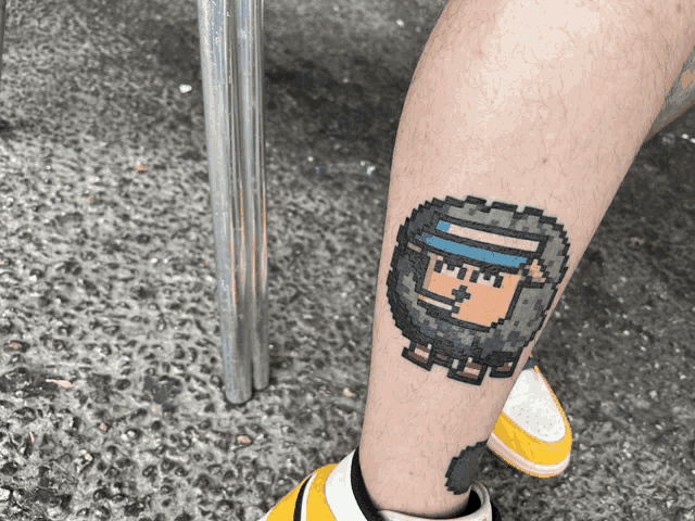 a pixel art tattoo of a man with a beard