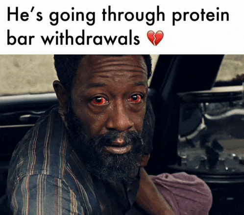 a man with red eyes is sitting in the back seat of a car with a broken heart behind him
