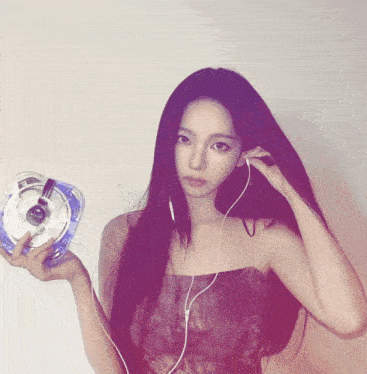 a woman wearing headphones is holding a device that says ' sd ' on it