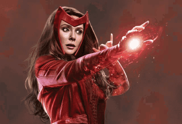 a woman in a red costume is holding a red object in her hand