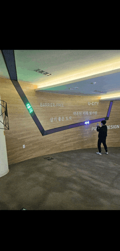 a man standing in front of a wall that says u-city on it