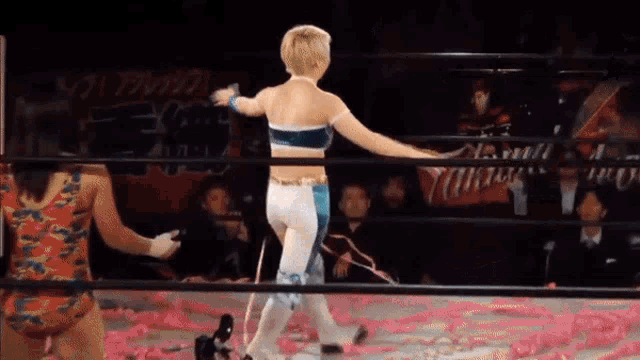 a woman in a wrestling ring with a sign in the background that says ' atsushi '