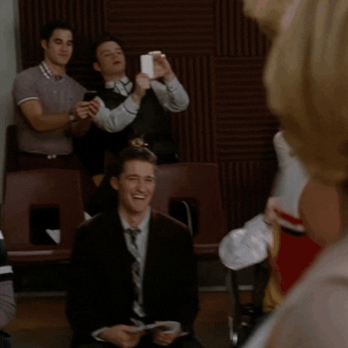 a man in a suit is taking a picture of himself with a cell phone