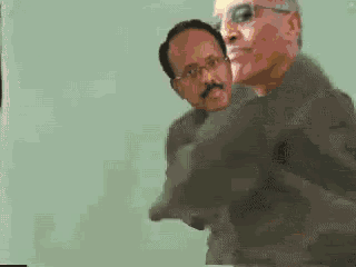 two men are standing next to each other and one has glasses
