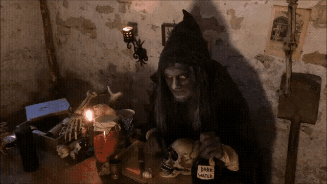 a bottle of dark water sits on a table next to a skeleton