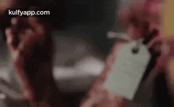 a person is holding a dead body with a tag on it .