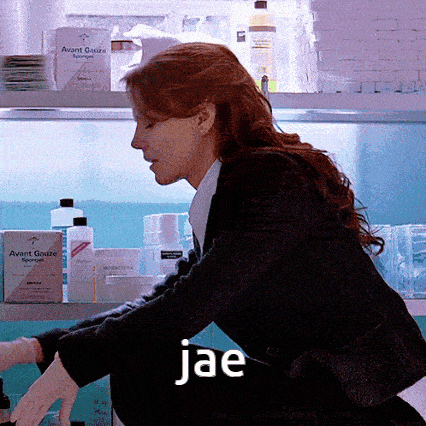 a woman in a black suit is kneeling down in front of a shelf that says avant gauze