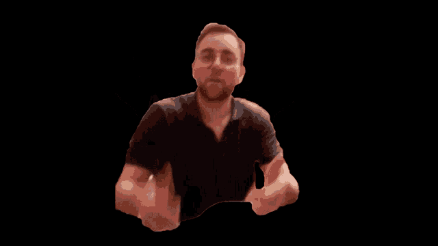 a man with glasses and a beard gives a thumbs up