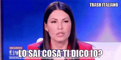 a woman in a red jacket is sitting in front of a screen that says trash italiano on it