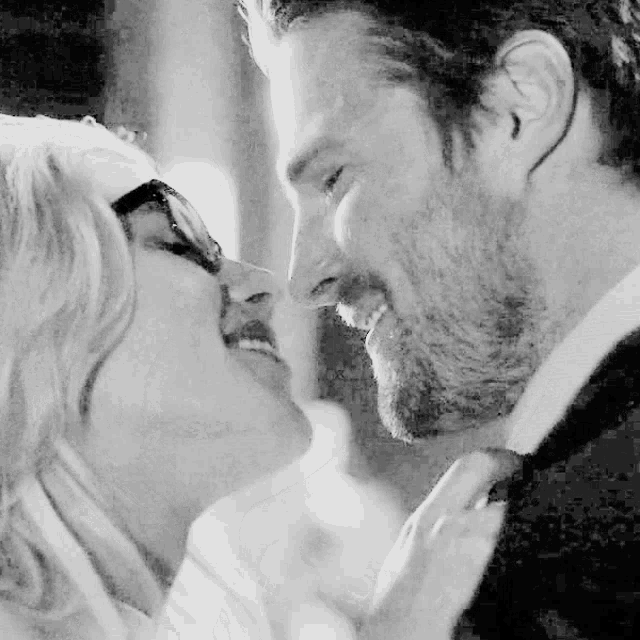 a man and a woman kissing in a black and white photo